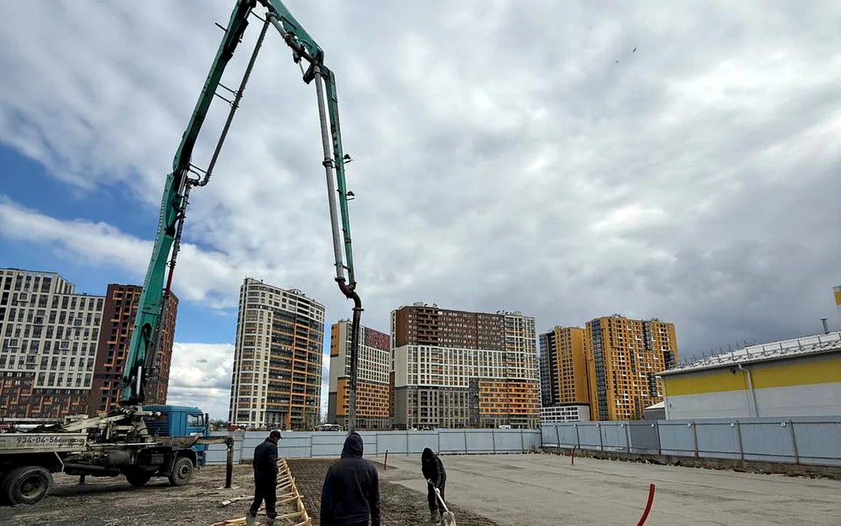Автобетононасос и бригада на крупной строительной площадке